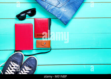 Set de voyage, Passeport, e-book, chaussures, lunettes de soleil, appareil photo. on a wooden surface turquoise, une vue de dessus Banque D'Images