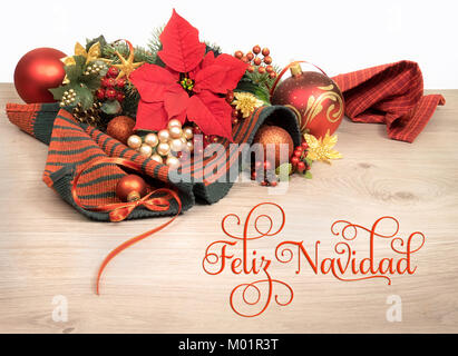 Fond de bois avec poinsettia et arbre de Noël décoré de brindilles, de texte sur l'image signifie 'Merry Christmas' en espagnol Banque D'Images