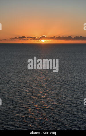 Océan Atlantique superbe coucher du soleil d'un navire de croisière dans les Caraïbes - les rayons de lumière qui sortent des nuages avec bleu jaune et orange & Hues Banque D'Images