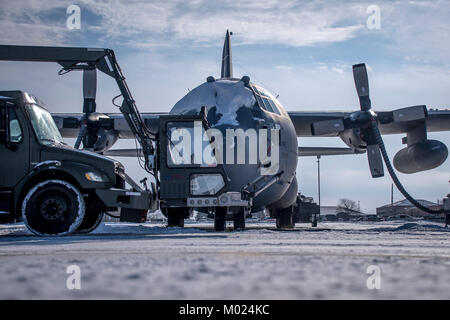 Aviateurs, l'exploitation d'un camion de dégivrage pour enlever la glace et la neige de la C-130H Hercules pendant le froid extrême le 16 janvier 2018, à la 179e Airlift Wing, Mansfield, Ohio. Banque D'Images