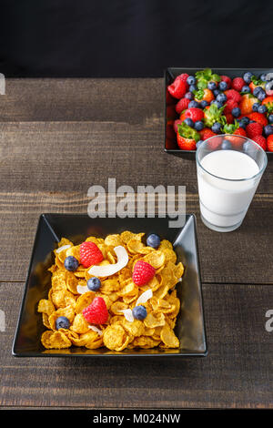 Les céréales et fruits rouges dans un bol carré noir petit-déjeuner le matin avec du lait Banque D'Images