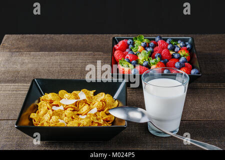 Les céréales et fruits rouges dans un bol carré noir petit-déjeuner le matin avec du lait Banque D'Images