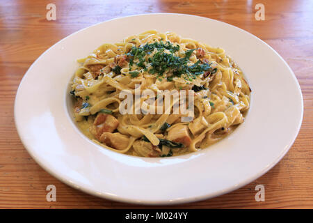 Fettuccine aux champignons et poulet avec sauce crémeuse sur table en bois Banque D'Images