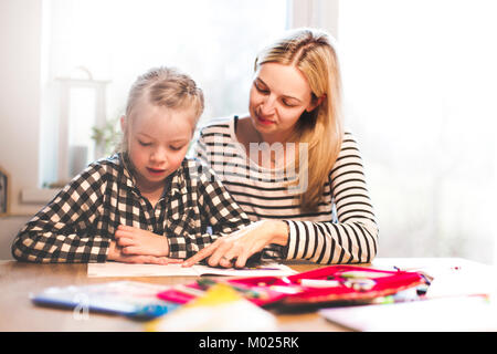 Mère et fille de faire le travail scolaire à la maison Banque D'Images