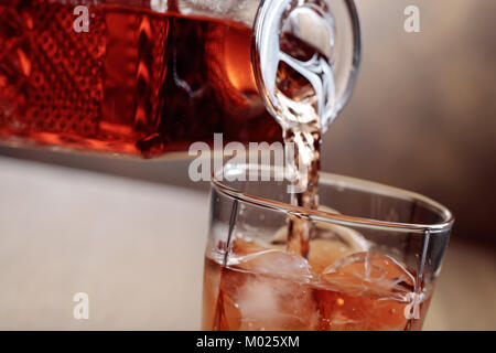 Whiskey est versé d'une carafe en verre avec de la glace. Copier l'espace. Banque D'Images