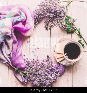 Tasse de thé, biscuits, et lilas fleur sur table en bois à partir de ci-dessus. Beau petit-déjeuner. Mise à plat style avec copie espace Banque D'Images