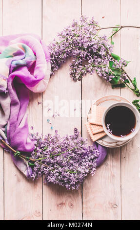 Tasse de thé, biscuits, et lilas fleur sur table en bois à partir de ci-dessus. Beau petit-déjeuner. Mise à plat style avec copie espace Banque D'Images