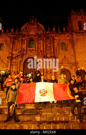 Les manifestants devant la cathédrale tenir un drapeau péruvien lors d'une protestation contre la grâce accordée à l'ancien président Alberto Fujimori, Cusco, Pérou Banque D'Images