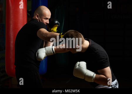 Combat de boxe entre deux jeune homme sur fond de sport moderne Banque D'Images