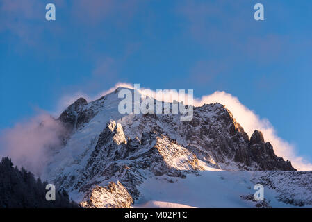 Les nuages de tempête soufflant derrière des sommets alpins Aiguille Vert et Les Drus sous le soleil d'après-midi contre le ciel bleu Banque D'Images