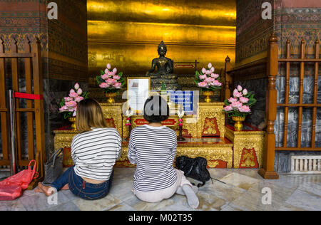 Asie,Thaïlande,Bangkok, Wat Pho temple,femme priant près du Bouddha couché Banque D'Images