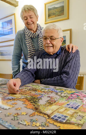 Vieux COUPLE TRAVAILLANT SUR UN PUZZLE UK Banque D'Images