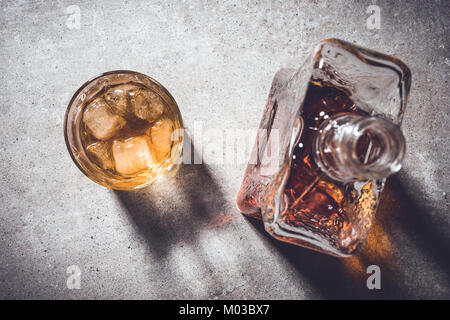 Bouteille de whisky et verre de whisky sur la table en pierre grise. Close up Banque D'Images