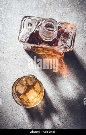 Bouteille de whisky et verre de whisky sur la table en pierre grise. Close up Banque D'Images