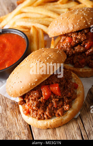 Sloppy Joes Sandwich fait maison avec la sauce et les frites sur la table verticale. Banque D'Images