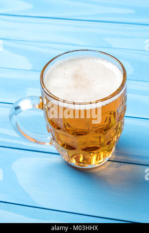 Chope de bière sur une table en bois bleu. Close up Banque D'Images