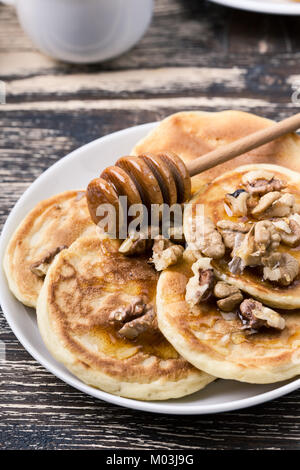 Brunch de la fête des mères avec de délicieuses crêpes au miel et noix sur table en bois rustique Banque D'Images