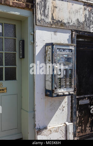 Une vieille machine à cigarettes sur le mur d'un atelier fermé dans la région de Deal, Kent, UK Banque D'Images