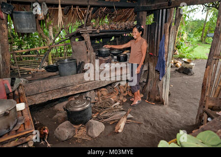 Une femme prépare un repas sur une flamme nue dans sa piscine 'Dirty' de Legazpi, près de cuisine du sud de l'île de Luçon, aux Philippines. Banque D'Images