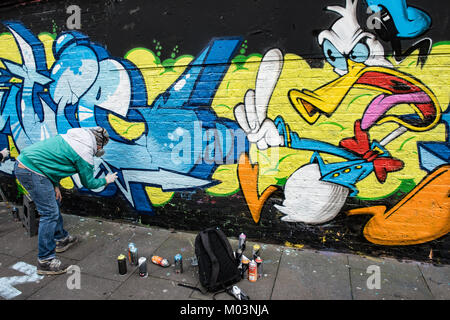 Brick Lane, East London est une zone créative pour les artistes. Ces images records graffiti artistes de finir un morceau d'art. Banque D'Images