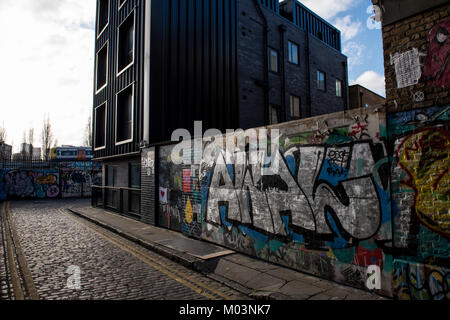 Grimsby Street, près de Brick Lane dans l'Est de Londres, est l'exemple même de la région où l'art de rue se mêle à l'habitation de style moderne. Banque D'Images