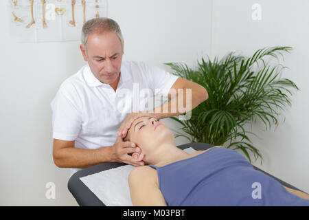 Visite à un chiroprakteur womans Banque D'Images