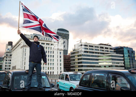 Londres, Royaume-Uni. 18 janvier, 2018. Un chauffeur de taxi noir brandit une Union Jack au cours d'une manifestation, au cours de laquelle le Pont de Londres a été bloqué par des centaines de chauffeurs de taxi noir, en réponse à la TfL en matière de gestion de l'Uber, poursuite de l'exploitation à Londres. Credit : Mark Kerrison/Alamy Live News Banque D'Images