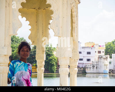 Une photographie en couleurs d'une belle fille indienne locale dans le contexte de la vieille ville et le lac à Udaipur Banque D'Images