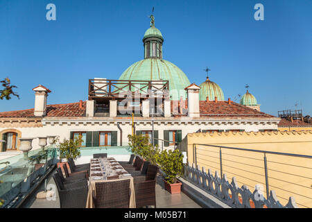 Les dômes de l'église de l'église de San Simeone Piccolo et tables sur le toit à l'Hôtel Carlton le long du Grand Canal en Vénétie, Venise, Italie, Europe. Banque D'Images