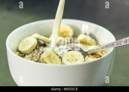 Idée de petit-déjeuner cerial bol de muesli avec tranches de bananes et de lait un de vos cinq par jour fruits et de glucides pour l'énergie à libération lente et c'est agréable Banque D'Images