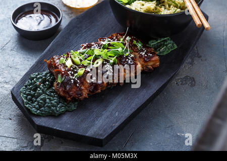 Style asiatique côtes de porc barbecue sur planche de bois glacées au miel, vue du dessus. Banque D'Images