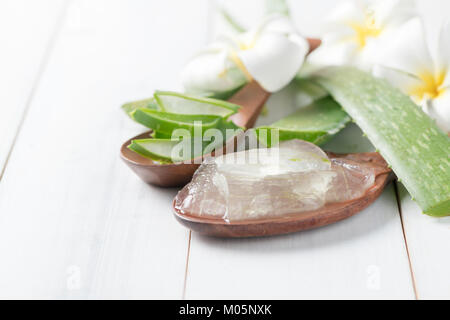 L'aloe vera en cuillère de bois sur fond de bois blanc, de plantes médicinales et soins de concept Banque D'Images