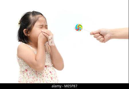 Enfant fille asiatique avec expression de dégoût contre candy et souffrant de maux isolé sur fond blanc, doux et sain refusant concep Banque D'Images