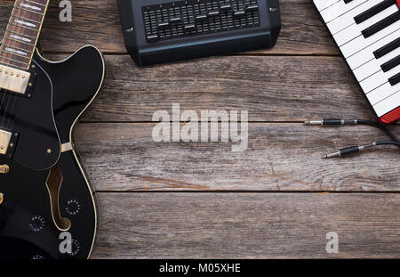 Guitares électriques, claviers, mixage et câbles sur un fond de bois Banque D'Images