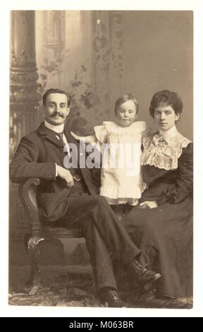 Studio de style édouardien carte postale de couple et l'enfant, les femmes portant une blouse avec col haut, l'homme a une impressionnante moustache, vers 1905, au Royaume-Uni. Banque D'Images
