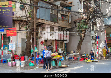 Hanoi, Vietnam - octobre 31,2017 : Les femmes d'acheter des fruits du vendeur de rue de leur location à Hanoi Old Quarter. Banque D'Images