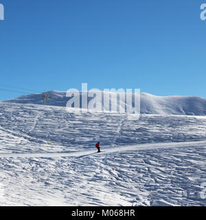 Skieur en descente sur une piste de ski de neige à nice matin soleil. La Géorgie, région Gudauri. Montagnes du Caucase en hiver. Banque D'Images