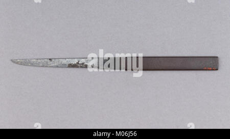 Un kozuka est un manche décoratif pour un petit couteau utilitaire (kogatana), souvent inséré dans une fente au dos d'un fourreau katana. Fabriqué à partir de matériaux comme le métal et le bois, il sert à la fois des buts fonctionnels et décoratifs dans la culture japonaise de la lame. Banque D'Images