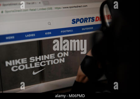 Une femme cherche sur le site web de Sports Direct Banque D'Images