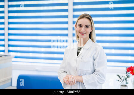 Portrait d'une jeune femme médecin portant un manteau blanc posant dans le bureau de l'hôpital Banque D'Images