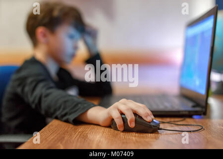 Peu dépendants gamer boy playing on laptop at home Banque D'Images