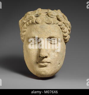 Cette tête de calcaire représente un votant masculin sans barbe, sculpté avec des traits sereins, remplissant probablement une fonction religieuse ou cérémonielle dans les pratiques anciennes. Banque D'Images