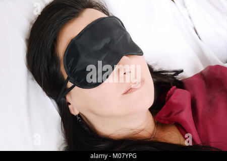 Close-up of Beautiful woman sleeping in bed avec un masque pour les yeux. À l'intérieur. Banque D'Images