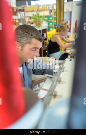 L'homme au travail à l'aide de la machine à coudre Banque D'Images