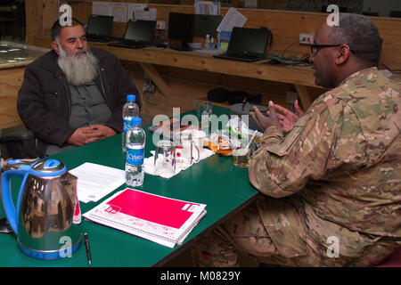 La Police nationale afghane (PNA) 303e Zone G1 Commander le Col Zikarullah se réunit avec la Force de police sud-est de l'équipe de Conseiller (PAT) G1 Advisor Le Major Nuir Hussein de la 3e Division d'infanterie, poste de commandement principal détachement opérationnel au cours de la clé de l'engagement du leader au Comité consultatif de la foudre de la plate-forme pour discuter de la formation du personnel afghan sur le personnel afghan et de solde (APPS). APPS est un système automatisé qui génère l'information sur la paie pour le ministère des Finances, tout en intégrant des autorisations, gestion de dossier personnel et les fonctions de la paie dans un système de défense nationale afghane et S Banque D'Images