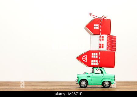 Toy voiture transportant une pile de maisons. Déménagement house concept Banque D'Images