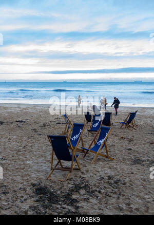 Tynemouth, Royaume-Uni - 30 Décembre, 2017 : King Edward's Bay matinée d'hiver scène de chaises de plage et les personnes qui prennent leurs chiens pour une promenade Banque D'Images