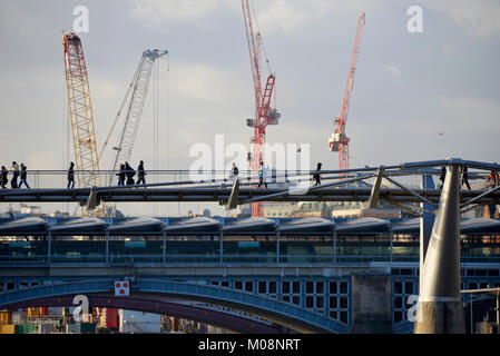 Millennium Bridge Londres avec les touristes qui marche sur les gens en face de plusieurs grues à tour et Blackfriars Bridge.Skyline Construction en cours Banque D'Images