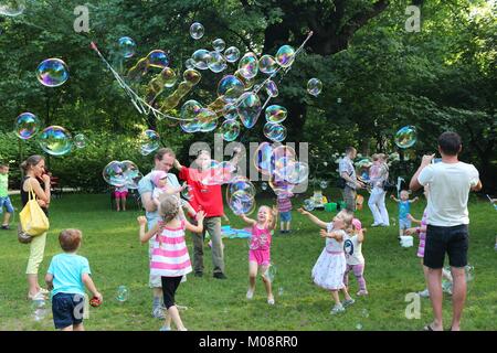 WROCLAW, Pologne - 6 juillet 2014 : les enfants jouent avec des bulles de savon dans un parc à Wroclaw. Wroclaw est la 4ème ville de France avec 632 067 personnes (201 Banque D'Images