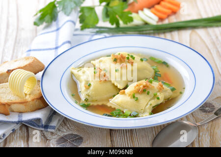 Avec le bouillon de légumes de style souabe ravioli farcis (qu'on appelle les «aultaschen') servi avec toast au beurre Banque D'Images